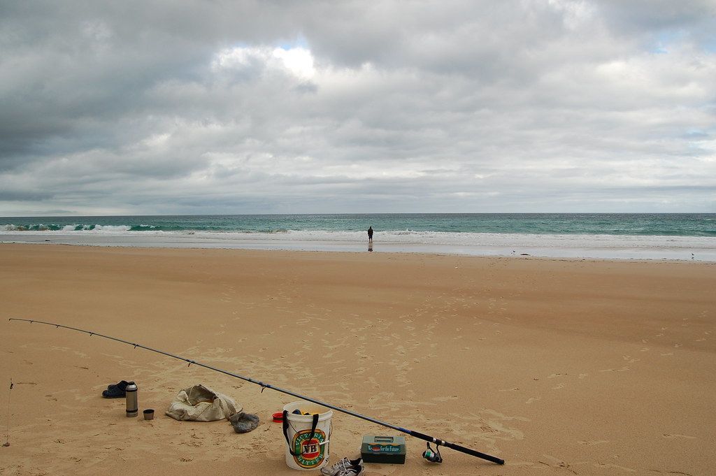 Fishing Gear Laid Out On A Sandy Beach With A Person Standing — SeaChange Parks Milton in Milton, NSW