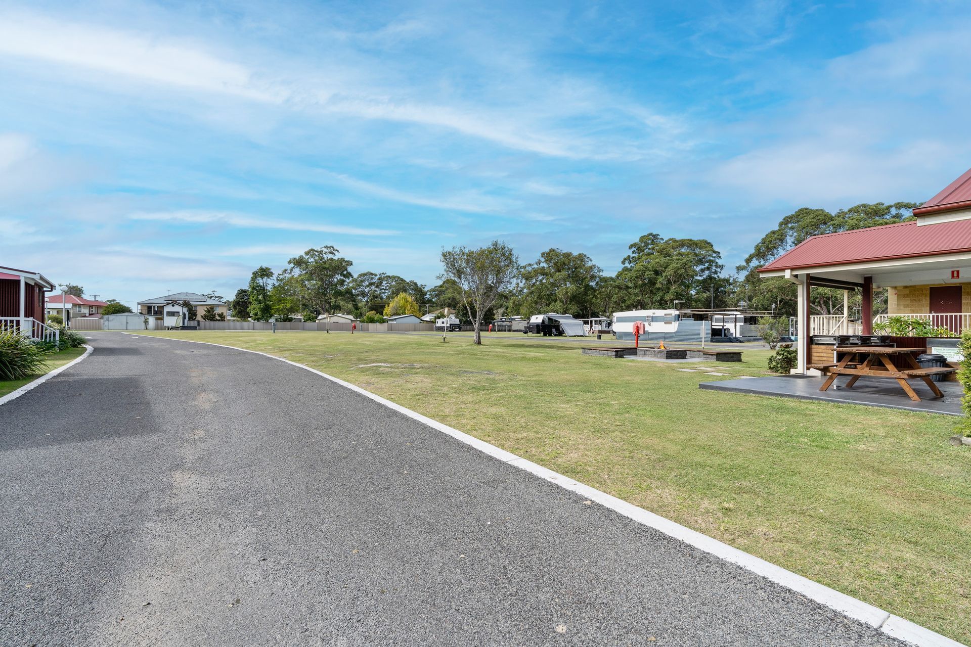 A Gravel Driveway Leading Through a Park with A Grassy Lawn, and A Building — SeaChange Parks Milton in Lake Conjola, NSW