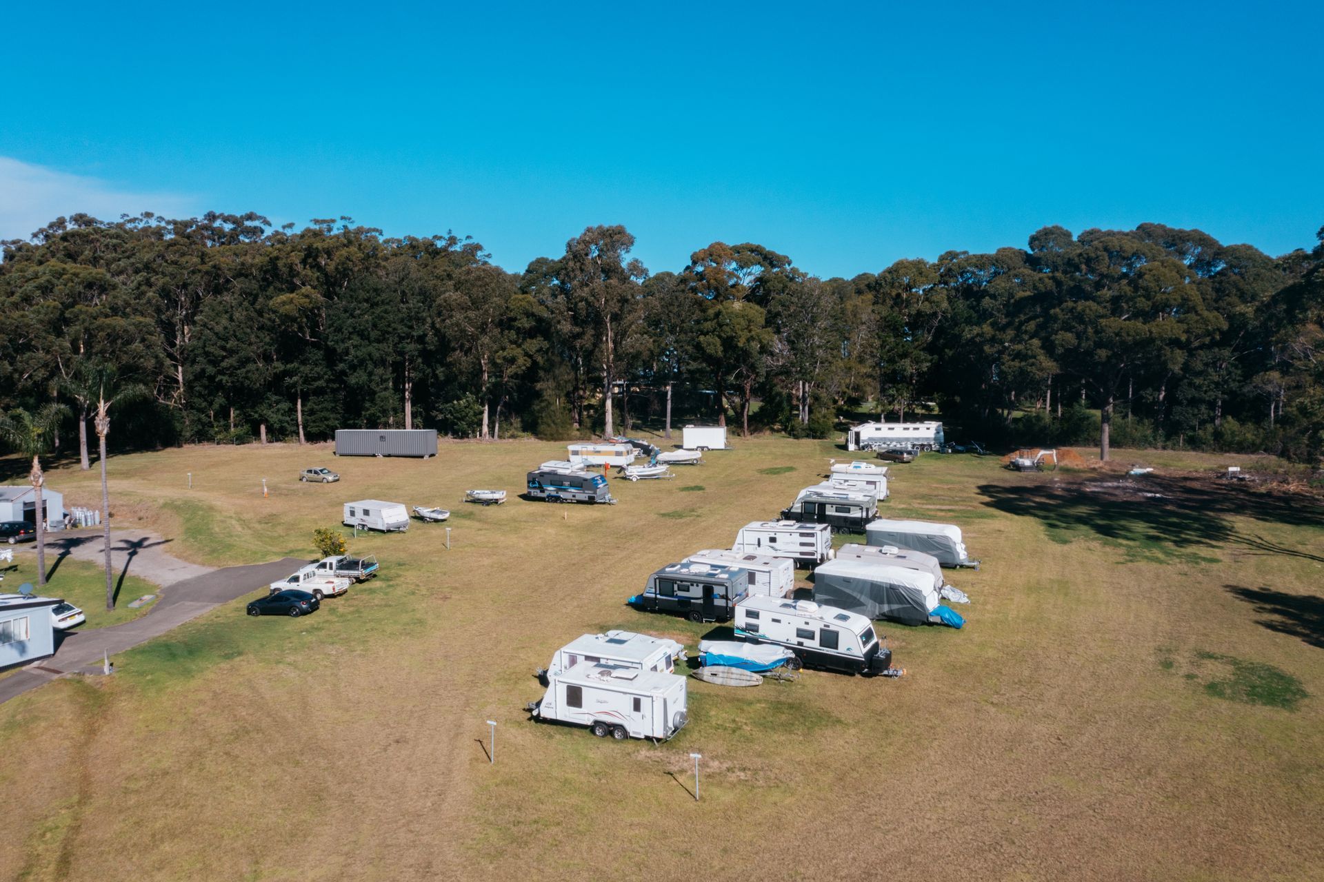 An Aerial View Of A Grassy Campground Filled With Parked Travel Trailers And Rvs — SeaChange Parks Milton in Milton, NSW