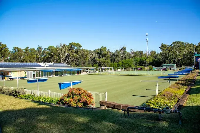 A Bowling Green With a Clubhouse Featuring Solar Panels, Set Against a Backdrop — SeaChange Parks Milton in Milton, NSW