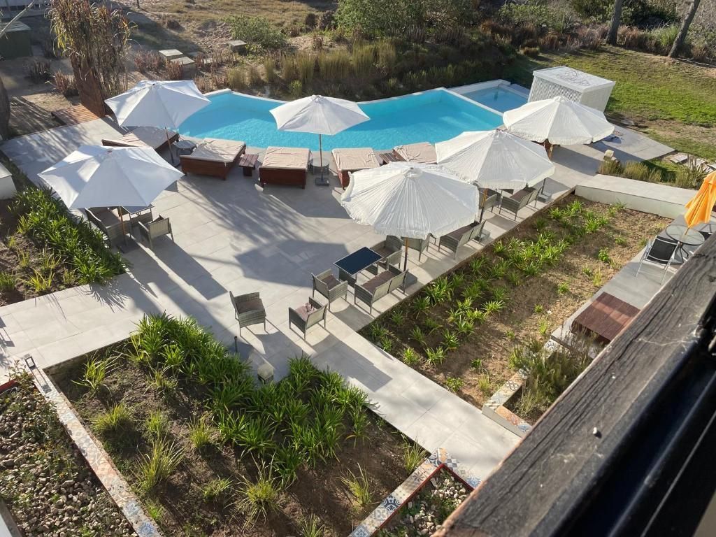 Una vista aérea de una piscina rodeada de sombrillas y sillas.