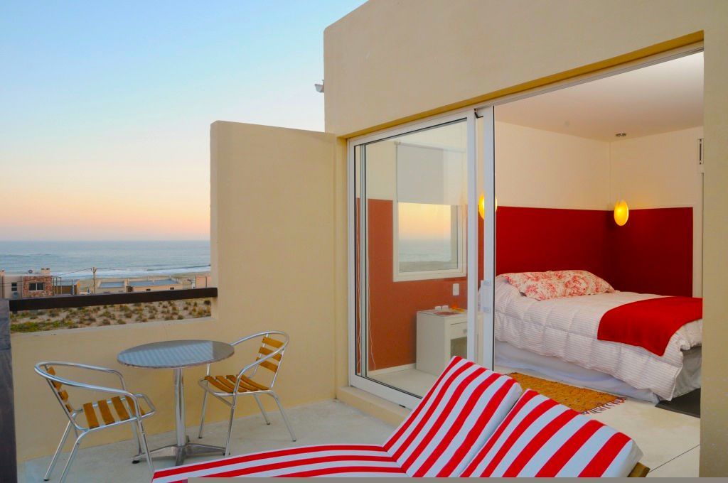 Un balcón con una cama y una mesa y sillas.