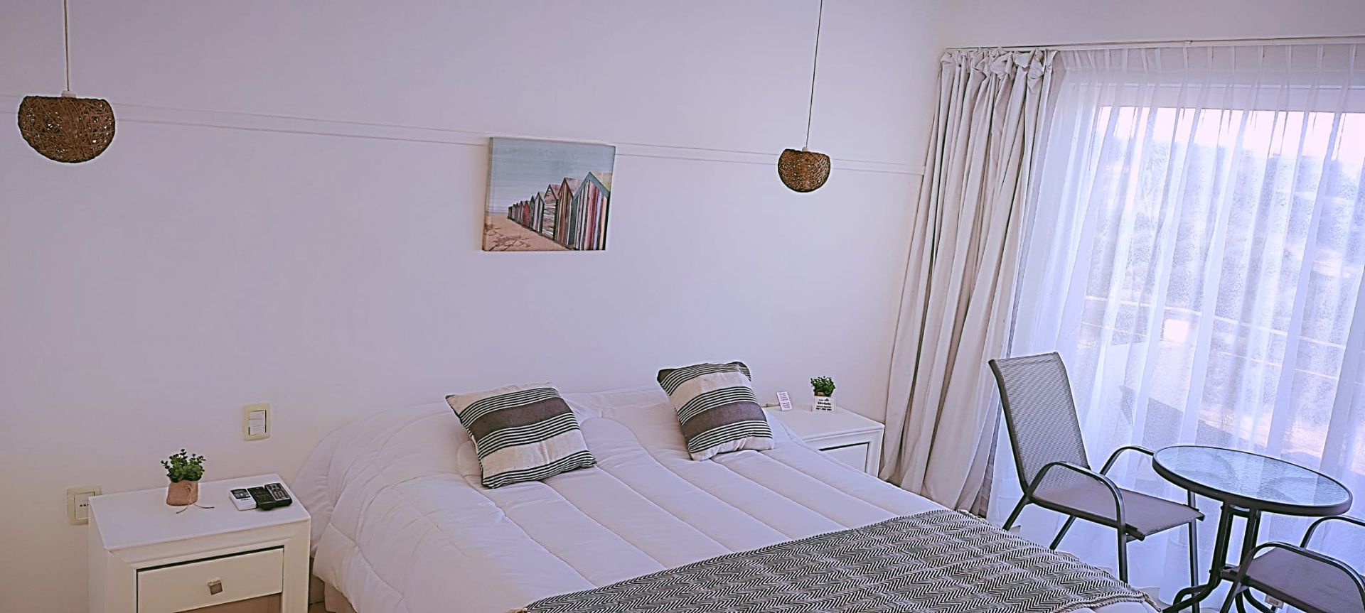 Un dormitorio con una cama, mesita de noche, mesa y sillas.