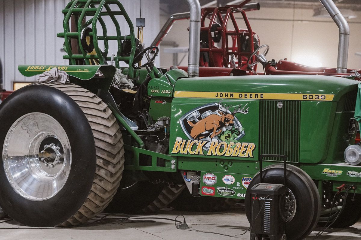 A green John Deere pulling tractor labeled 