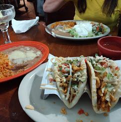 Table with tacos, rice, and beans at a restaurant meal