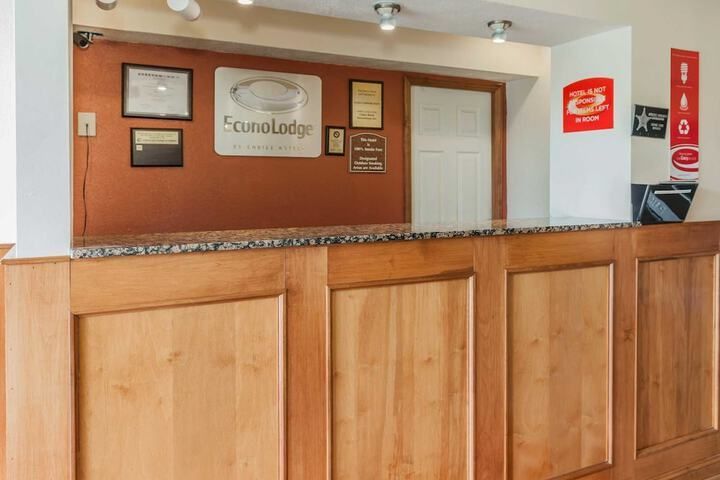Hotel lobby reception desk with wood paneling and orange accent wall