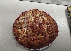 Cheese pizza on a white plate on a kitchen counter
