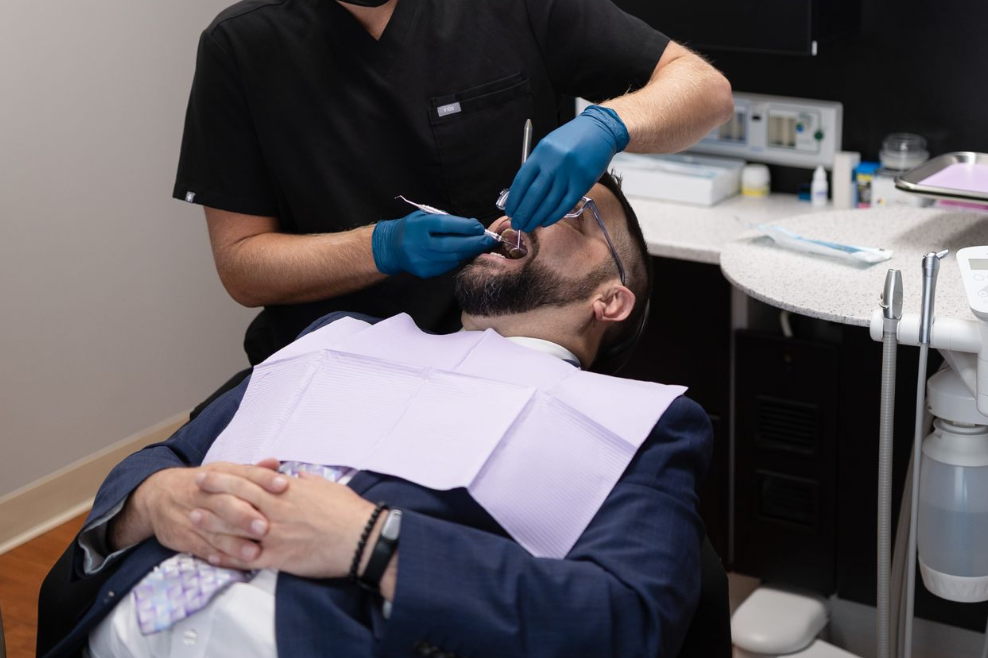 A man lying in a dental chair getting his teeth checked