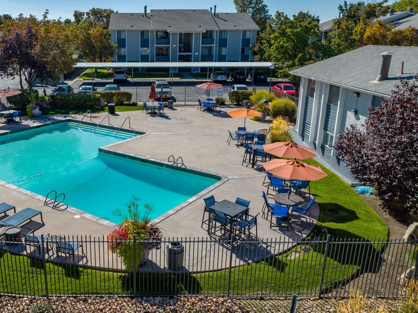 a large swimming pool with tables and chairs around it