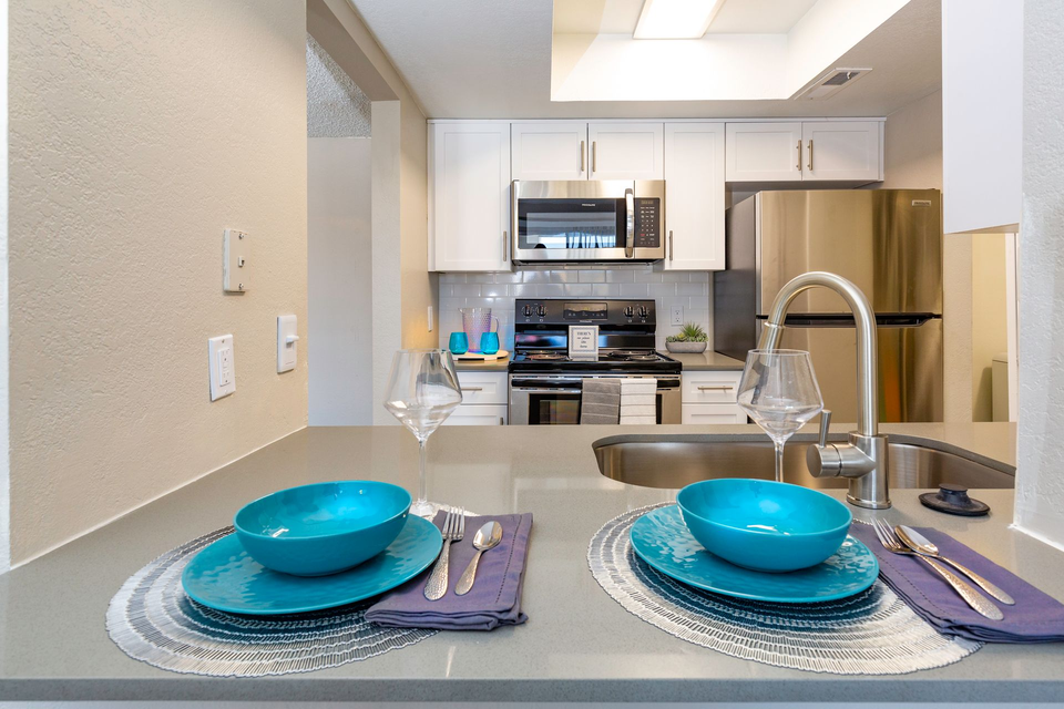 a kitchen with two blue bowls and plates on the counter .