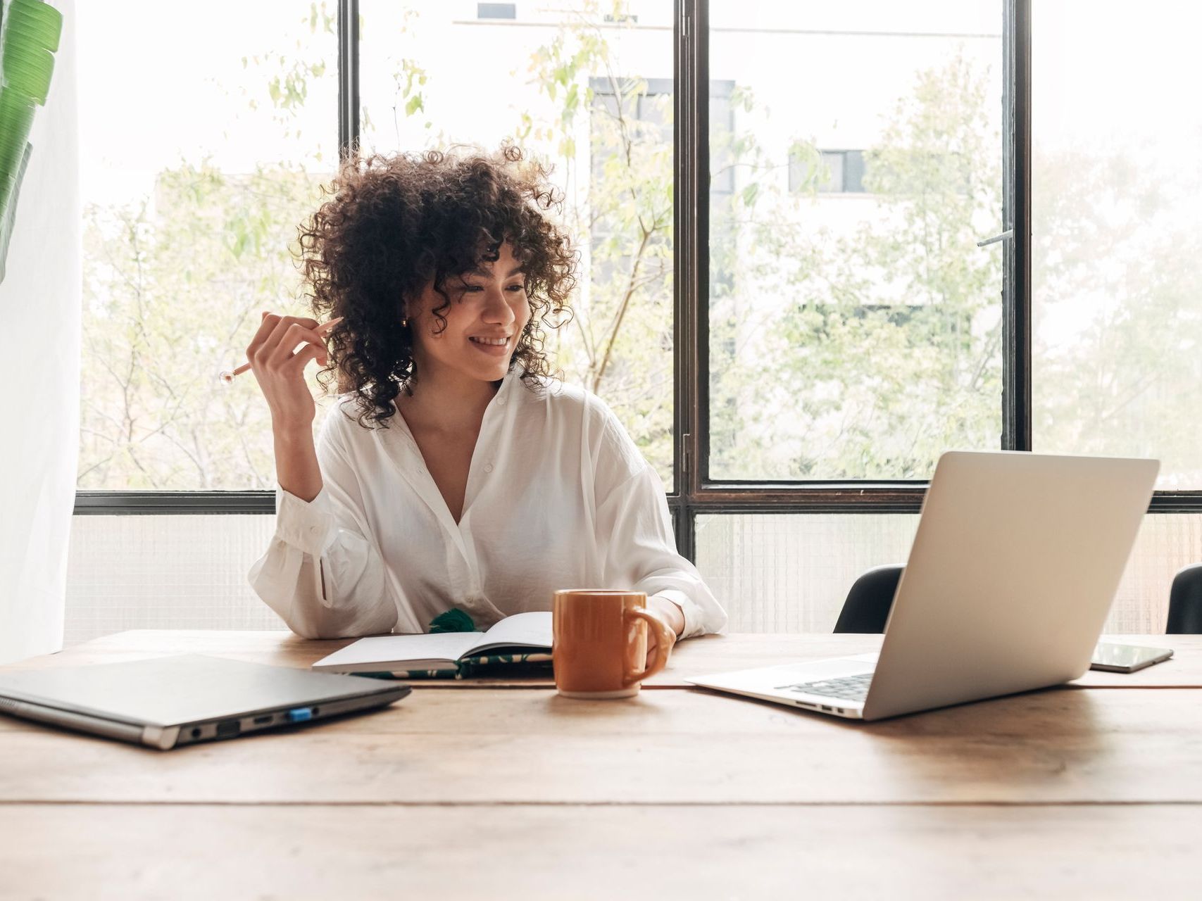 Woman sitting at a table looking at her laptop