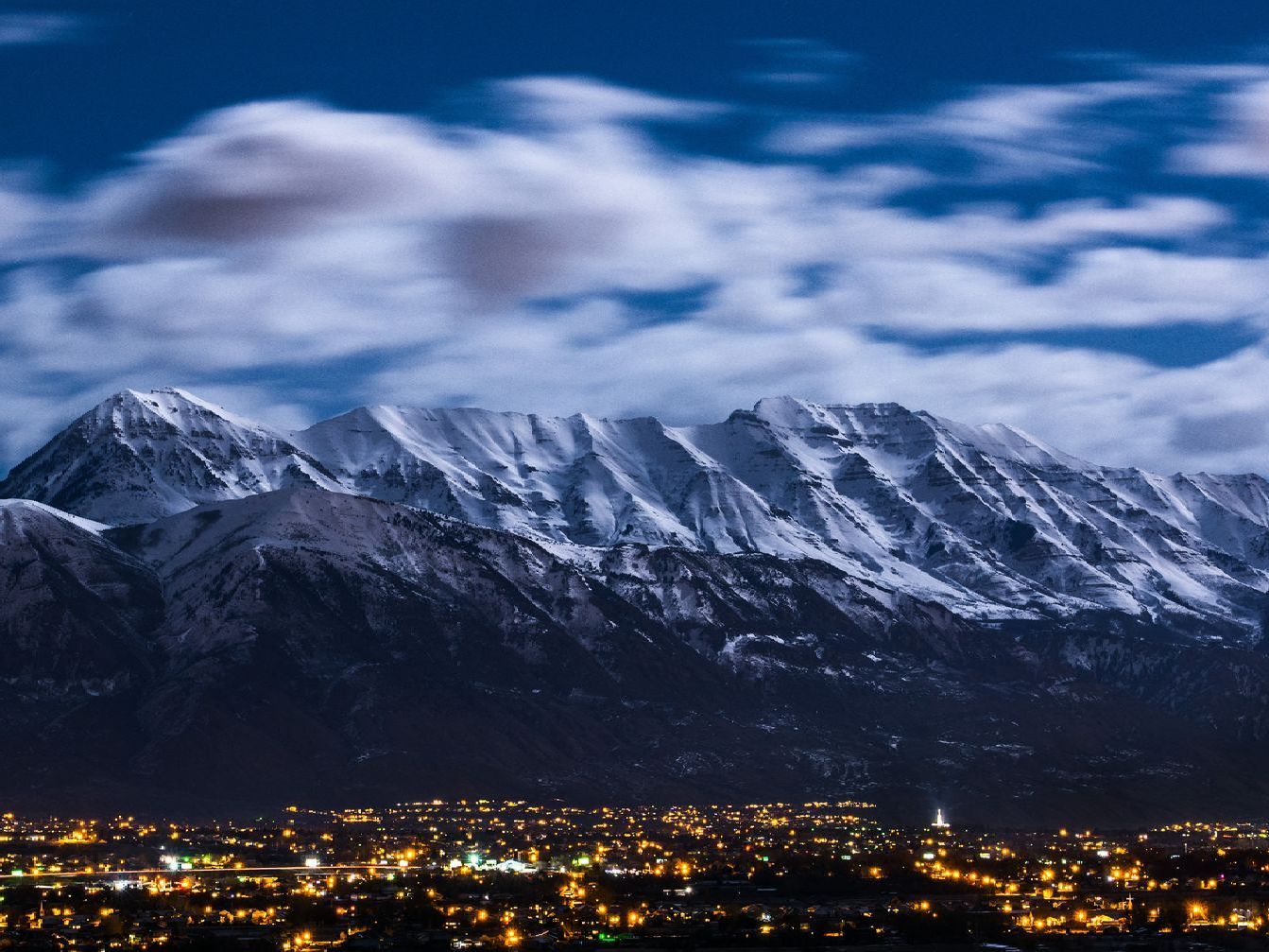 a snowy mountain with a city in the foreground