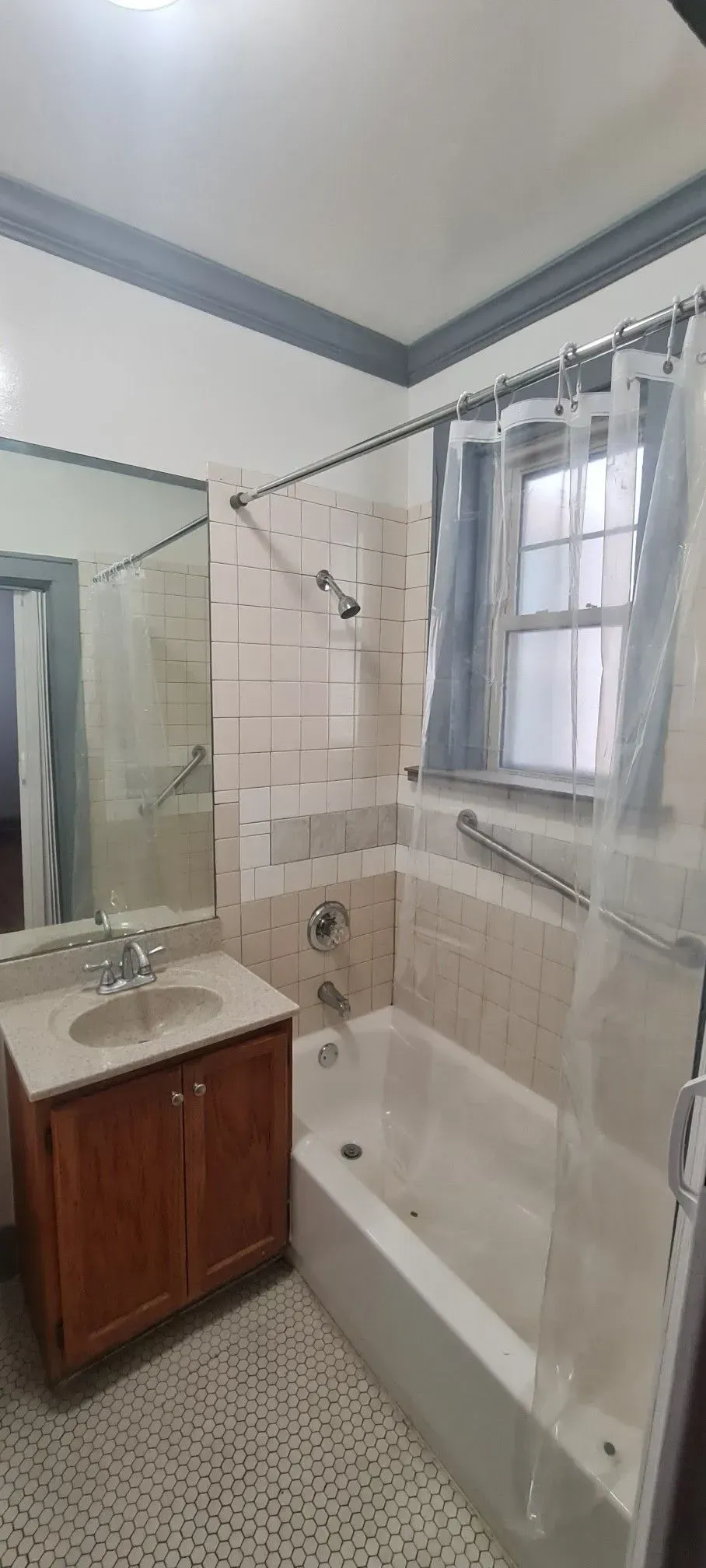 A bathroom with a sink , tub , shower and mirror.
