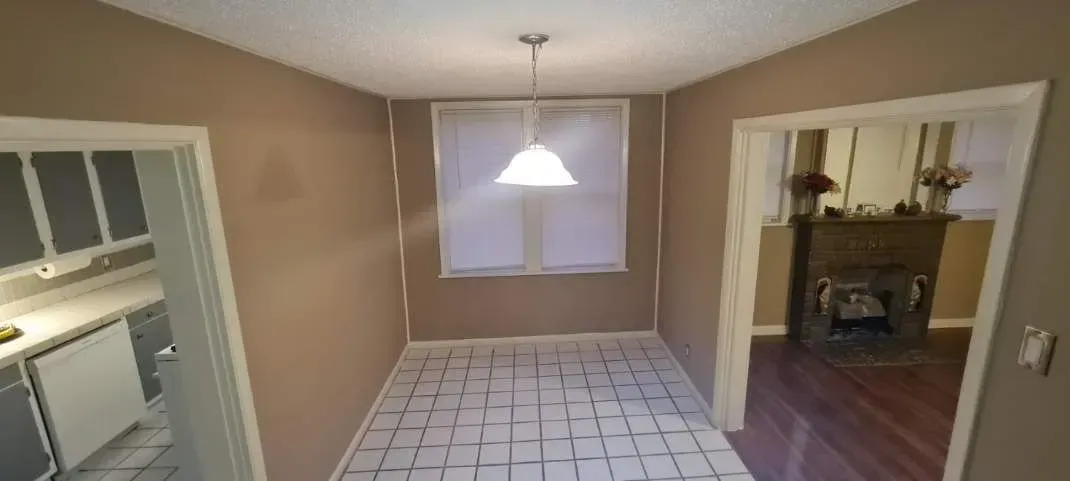 There is a light hanging from the ceiling in the dining room.
