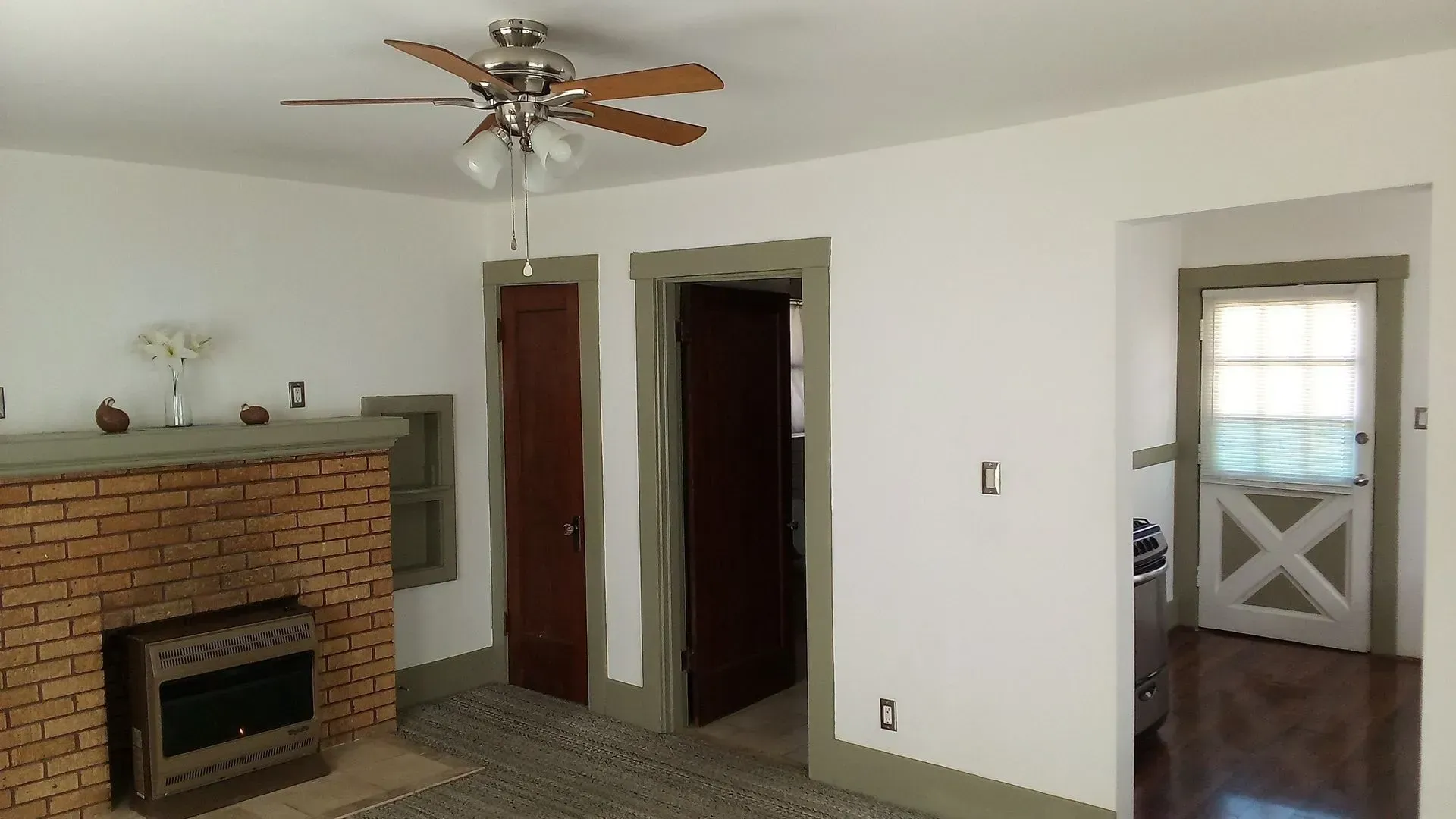 A living room with a fireplace and a ceiling fan