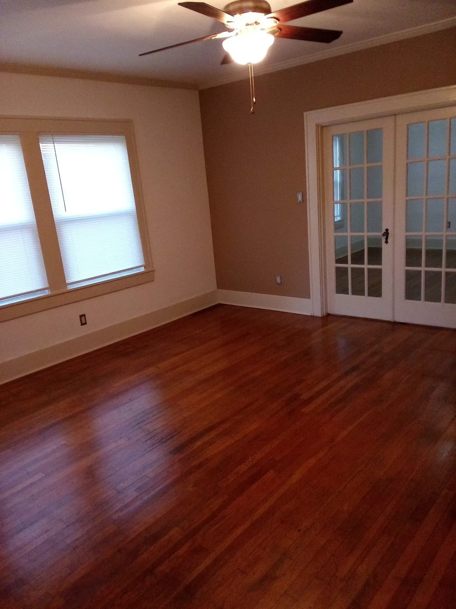 A living room with hardwood floors and a ceiling fan
