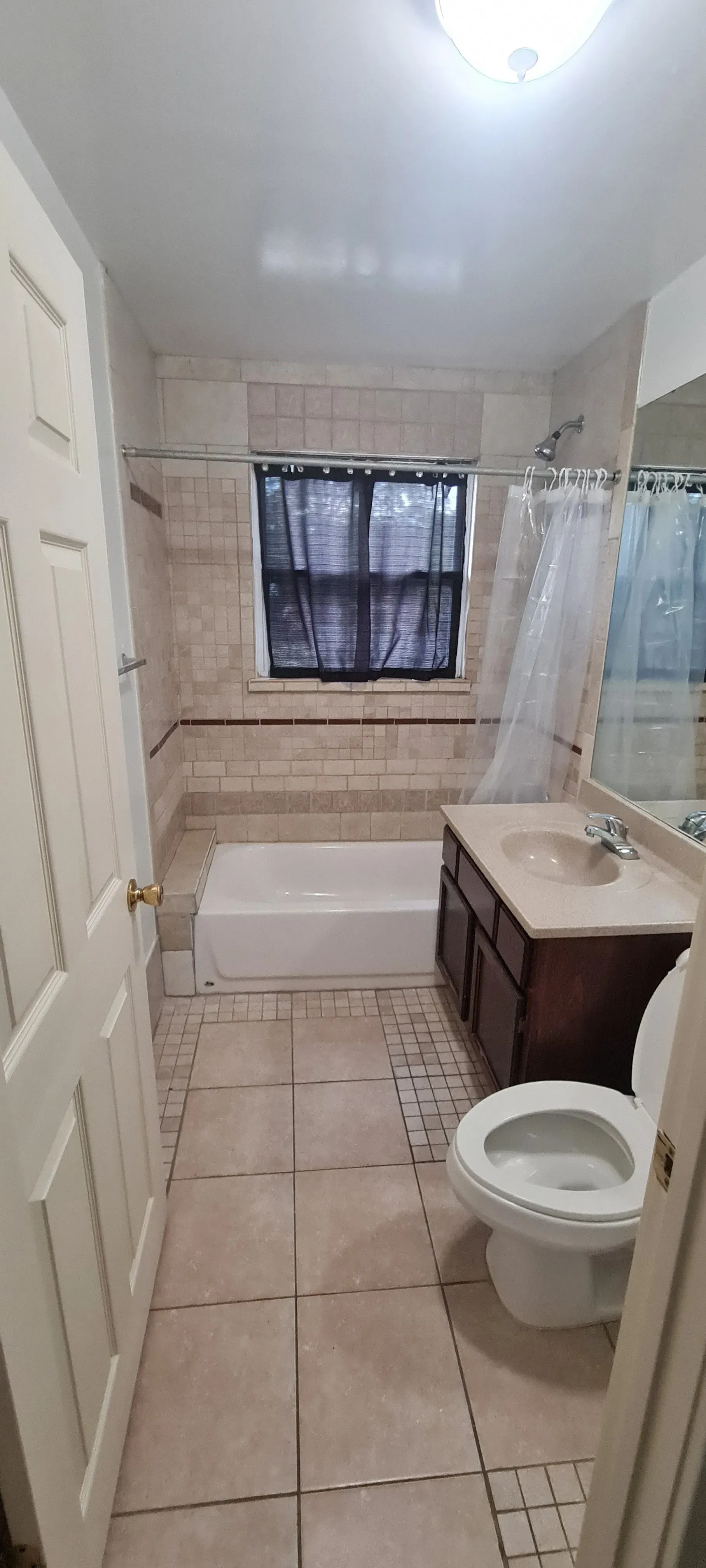 A bathroom with a toilet , sink , tub and shower.