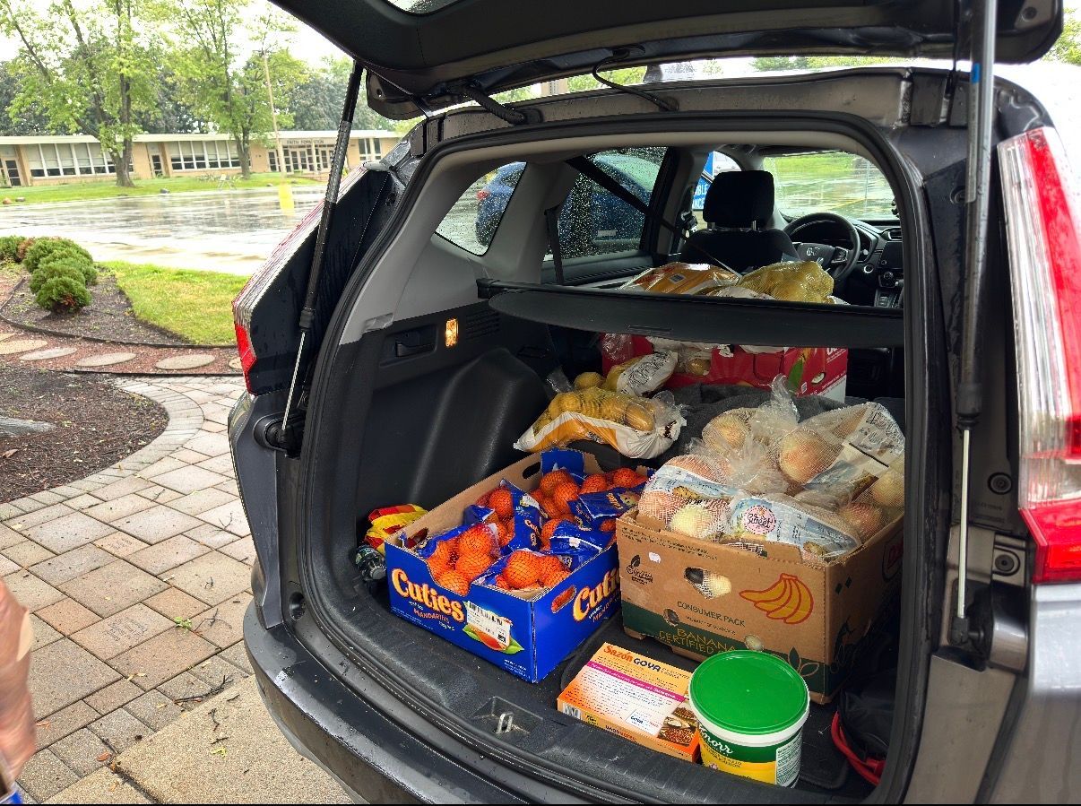 Open car trunk packed with groceries and food boxes in a parking area