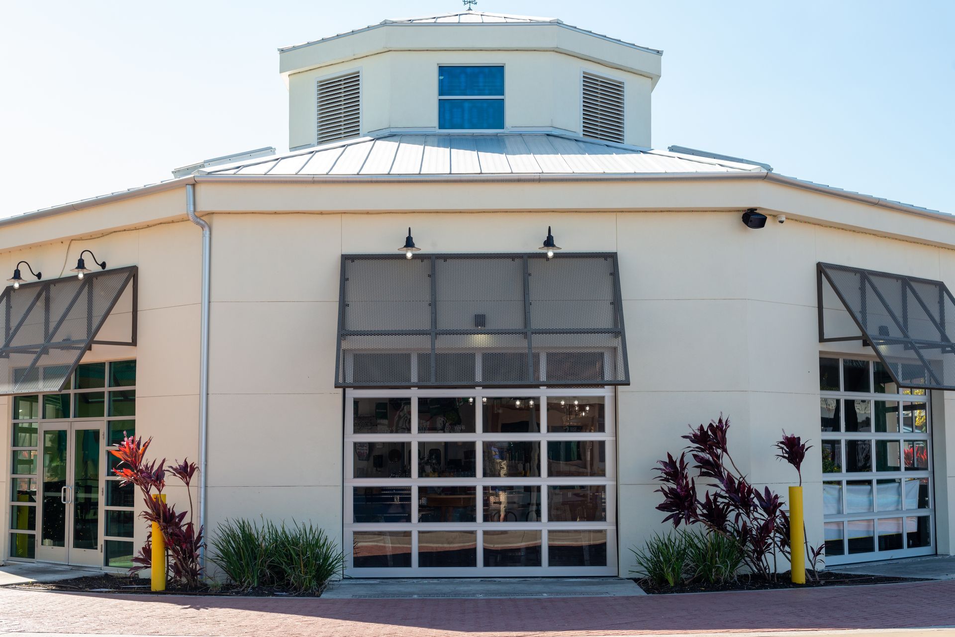 White, octagonal building with glass doors, awnings, and a domed roof.