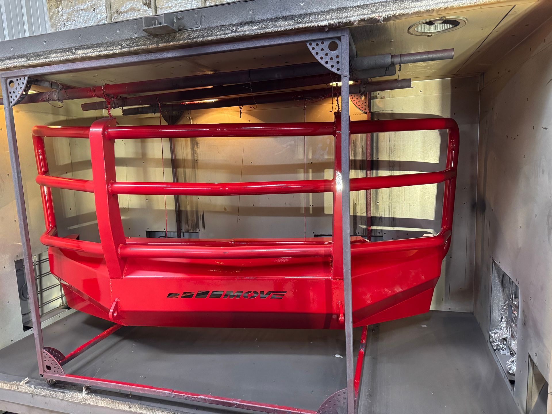 Red industrial lifting platform with safety rails inside a concrete loading bay