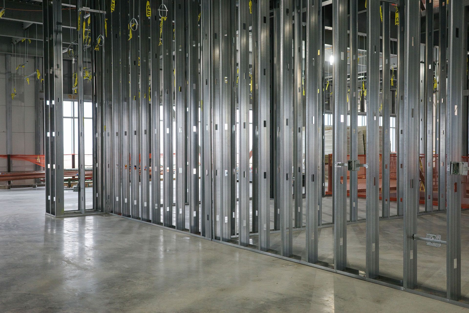 Unfinished interior with metal wall framing and a concrete floor under construction