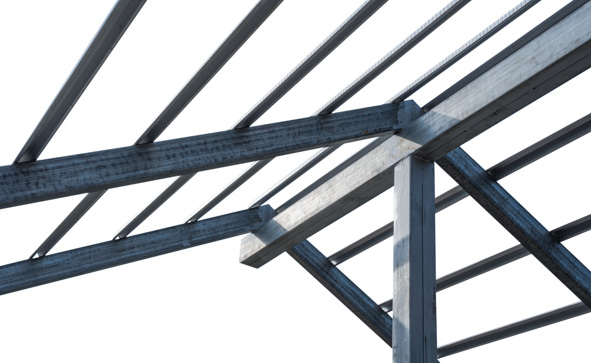 Steel building frame under construction with white wall panels against a partly cloudy sky