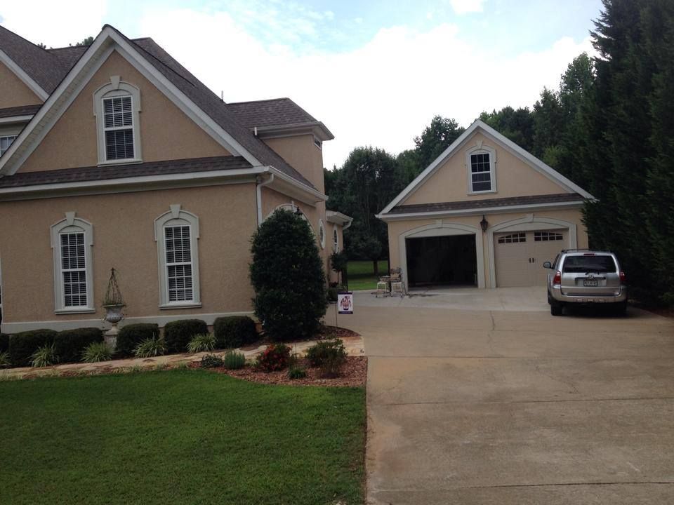 A car is parked in front of a large house