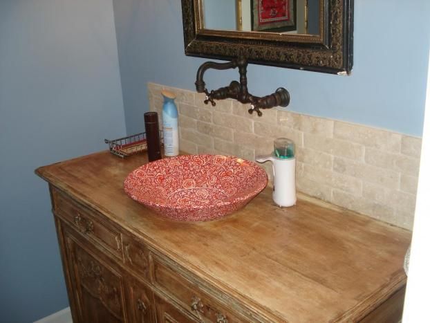 A bathroom with a red sink and a mirror