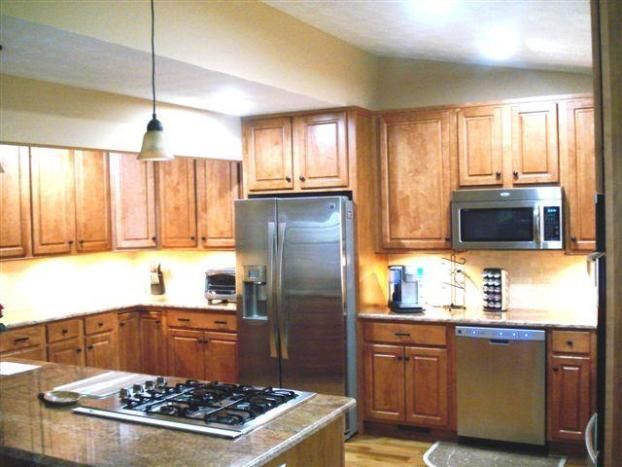A kitchen with stainless steel appliances and wooden cabinets