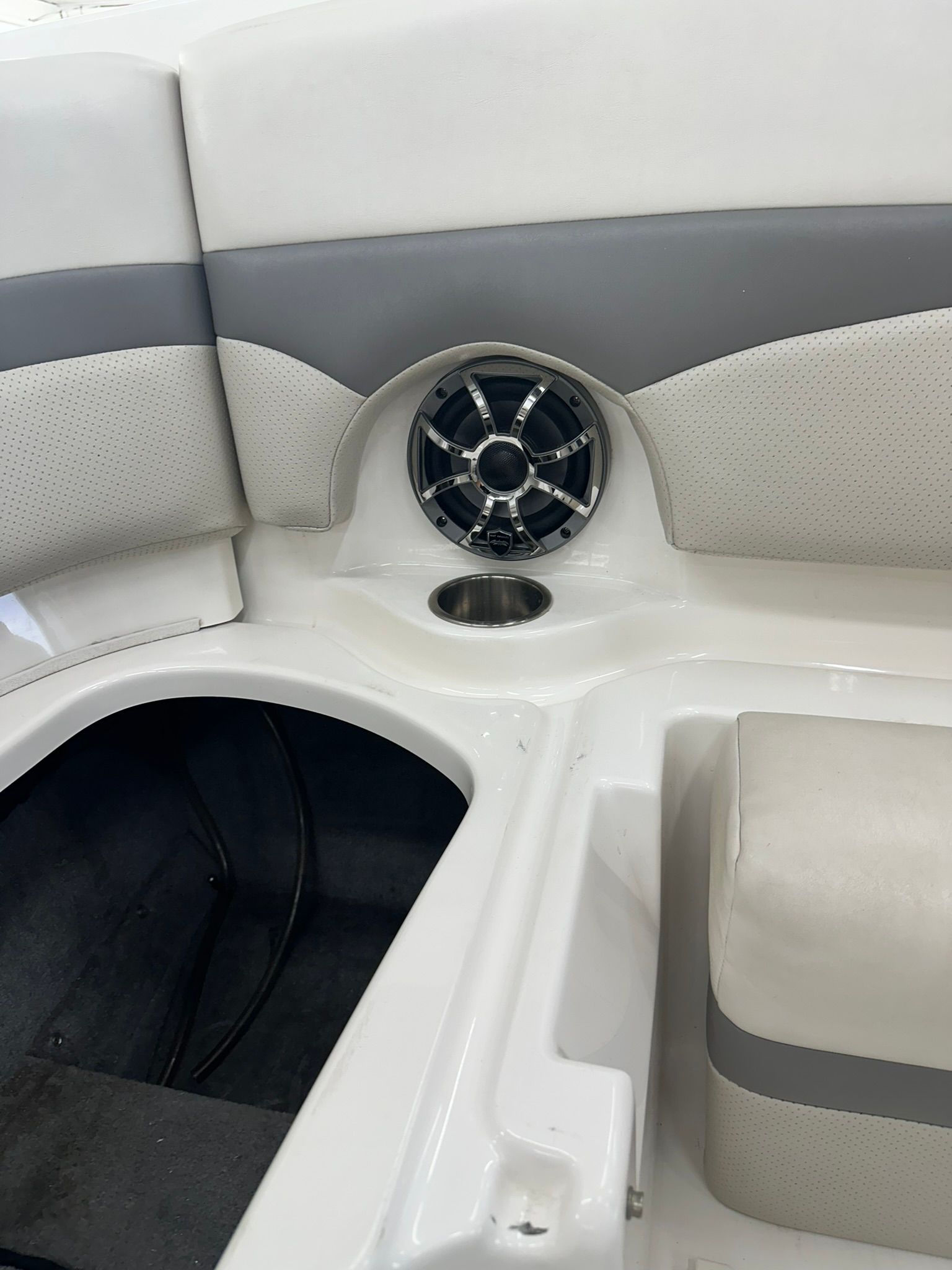 White boat interior with speaker, cupholder, and seating.