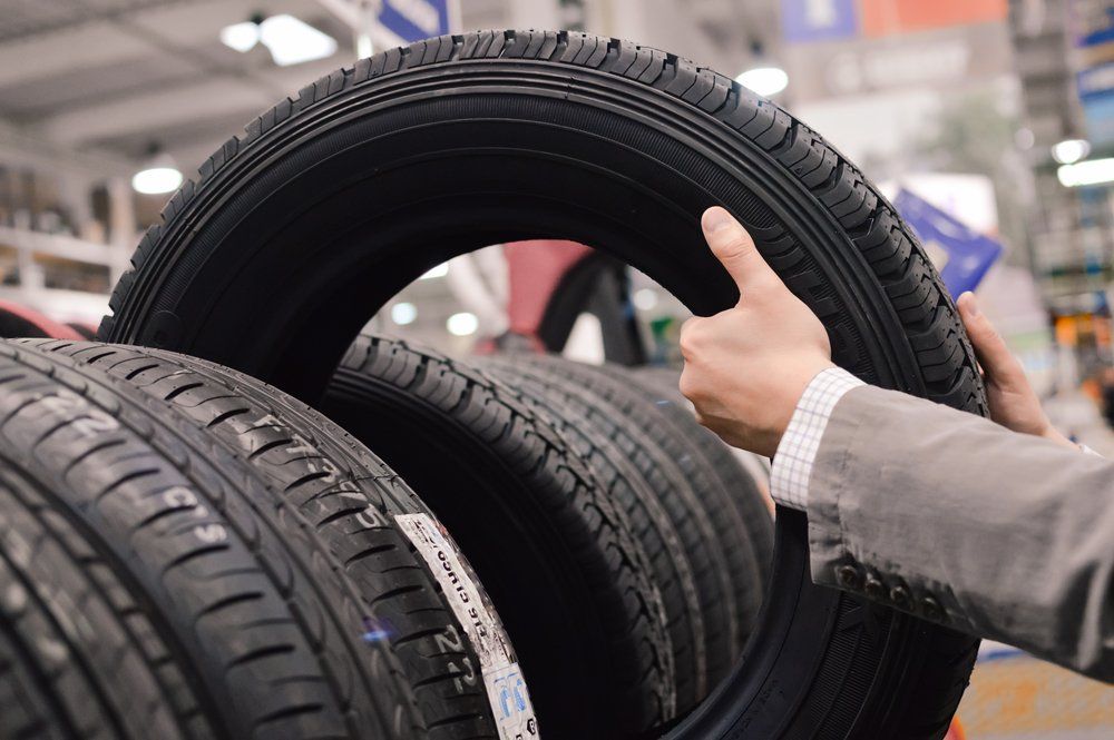 Man Picking New Tyre in the Shop — GK Denney Tyres in Coffs Harbour, NSW
