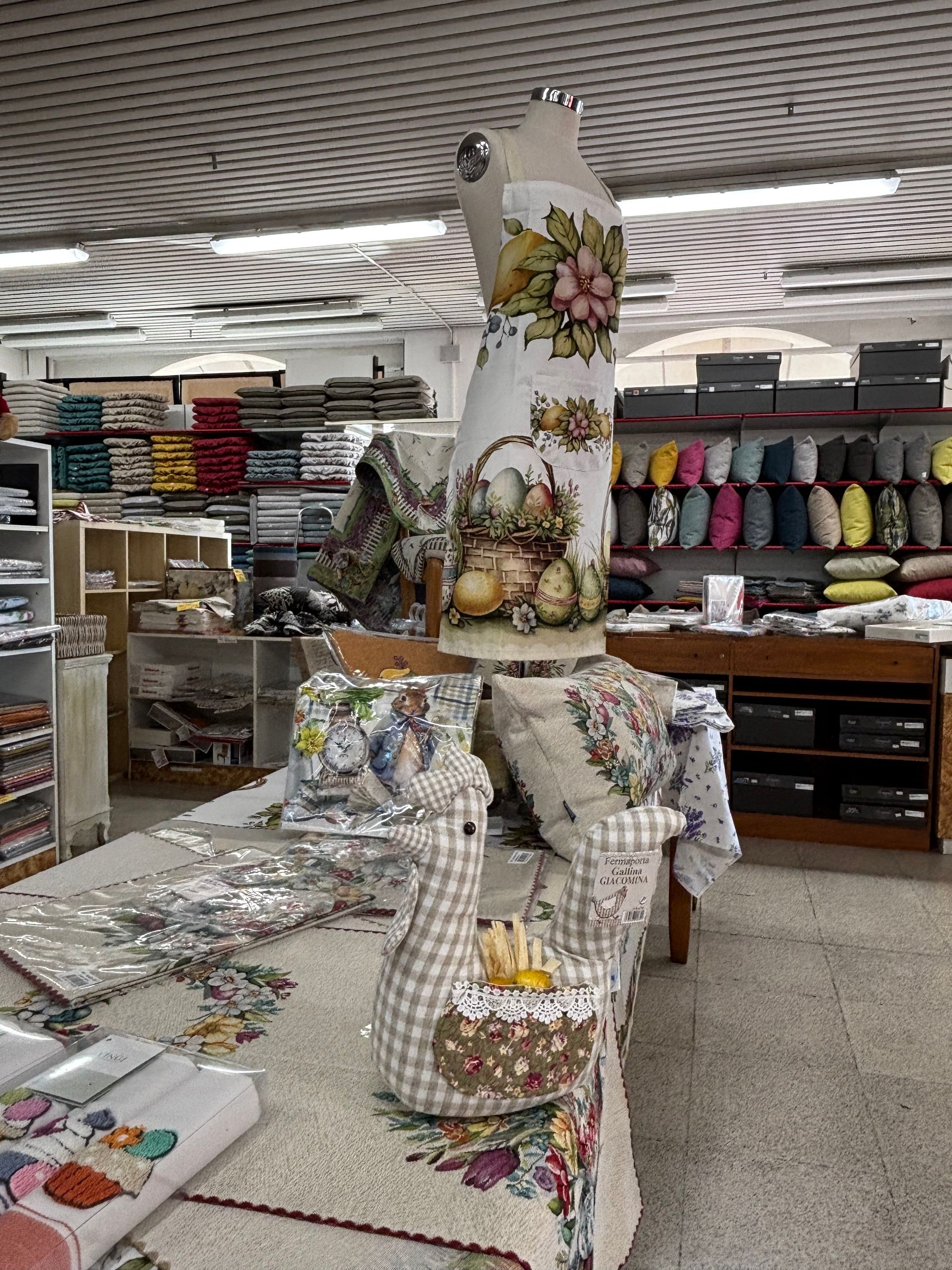 Un manichino è seduto su un tavolo in un negozio di tessuti.