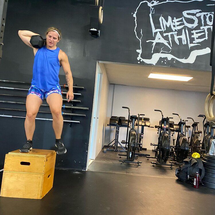 A man is jumping on a box in front of a sign that says limestone athlete