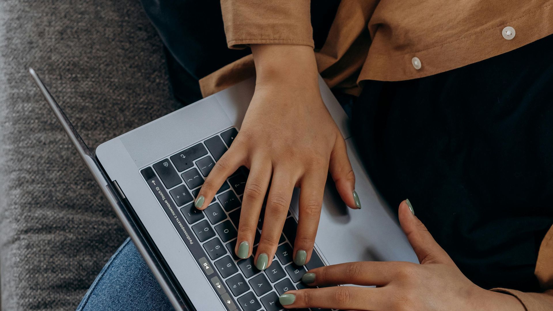 A person is typing on a laptop computer at a table.