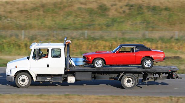 Long-haul tow of vintage car on flatbed tow truck