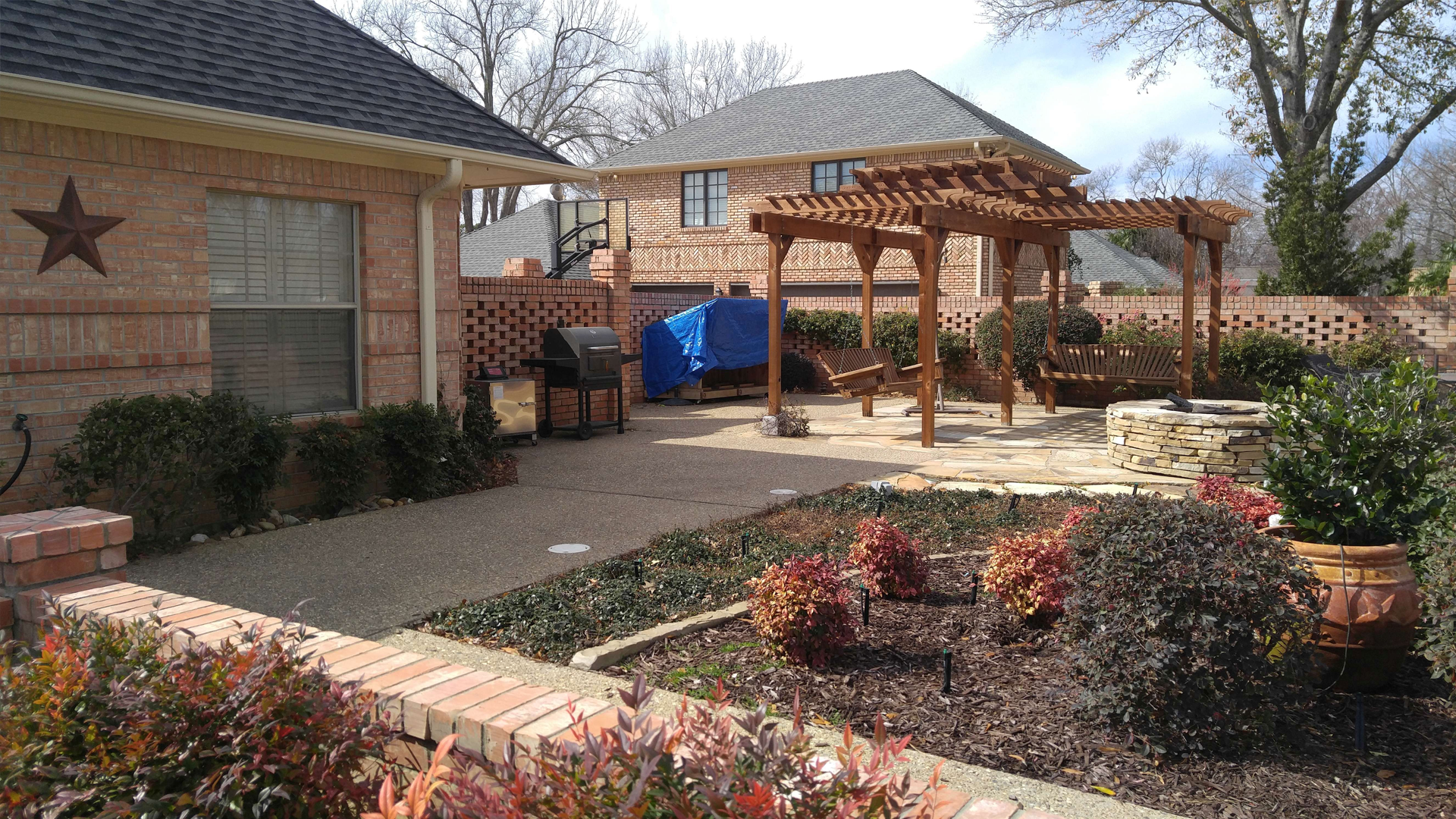 A brick house with a pergola in the backyard