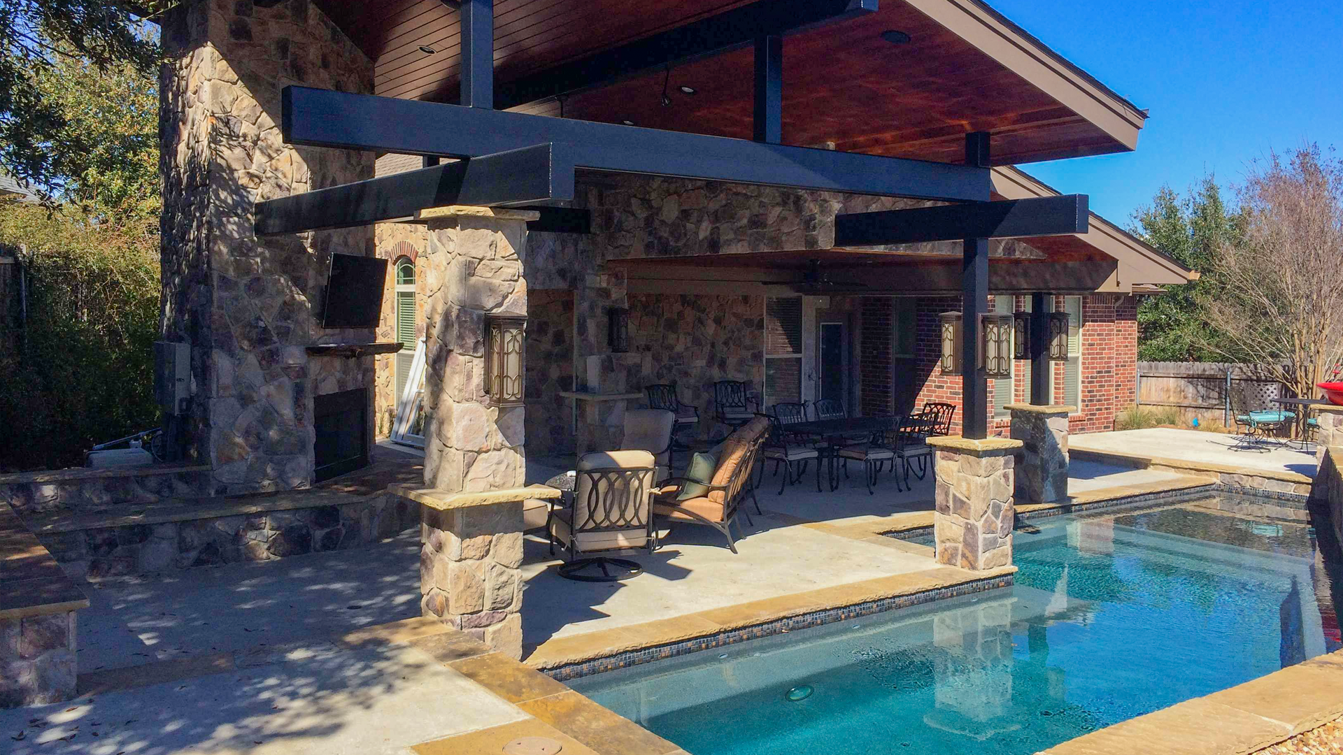 There is a large swimming pool in the backyard of a house.