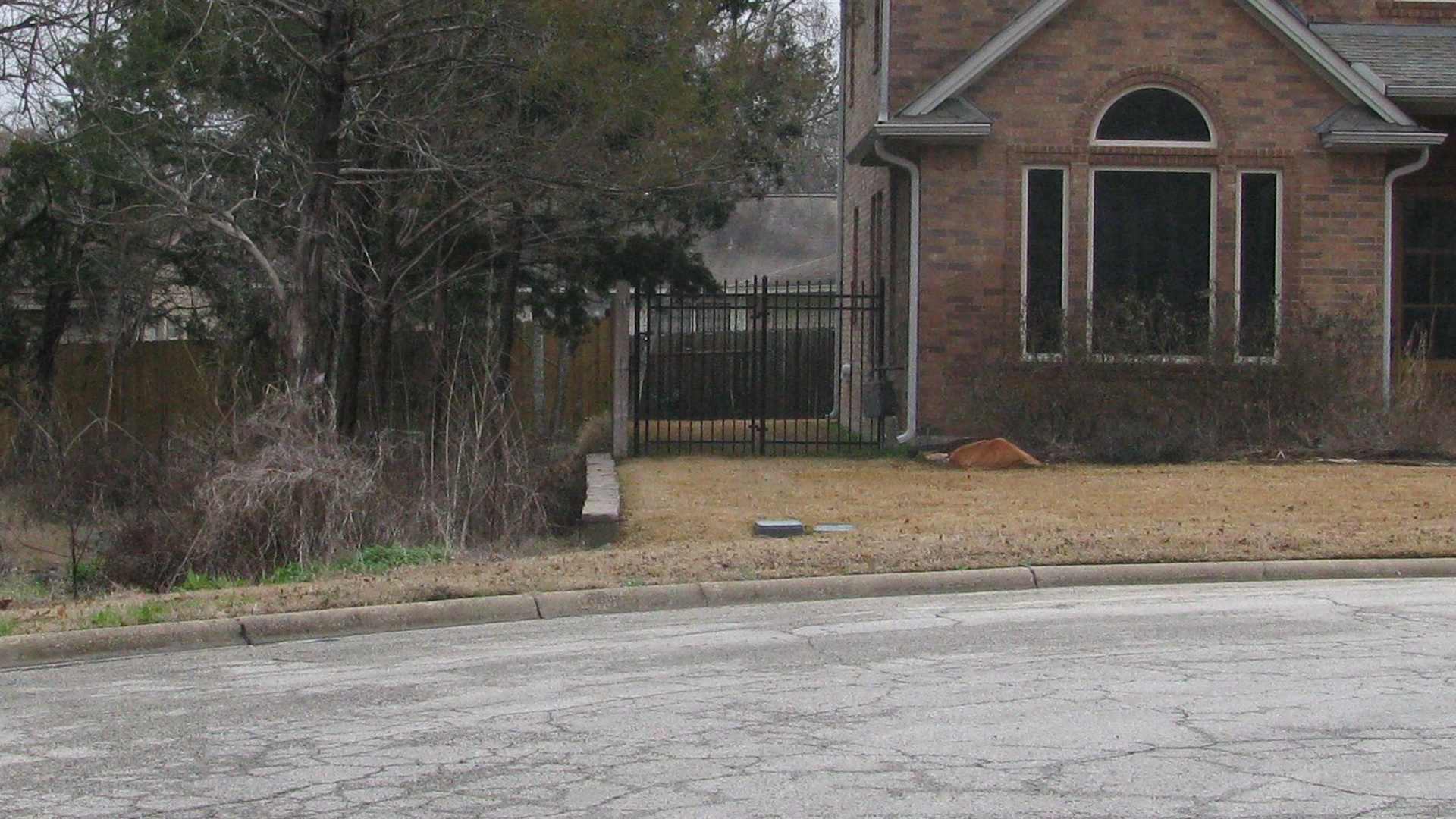 A brick house with a fence in front of it