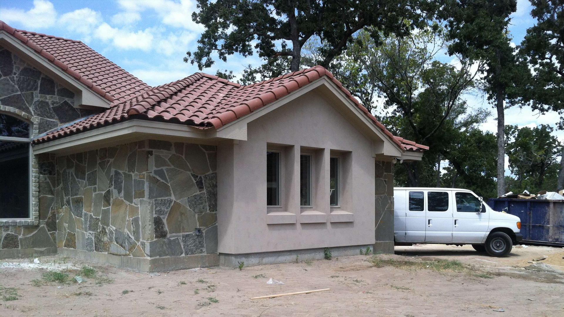 A white van is parked in front of a house