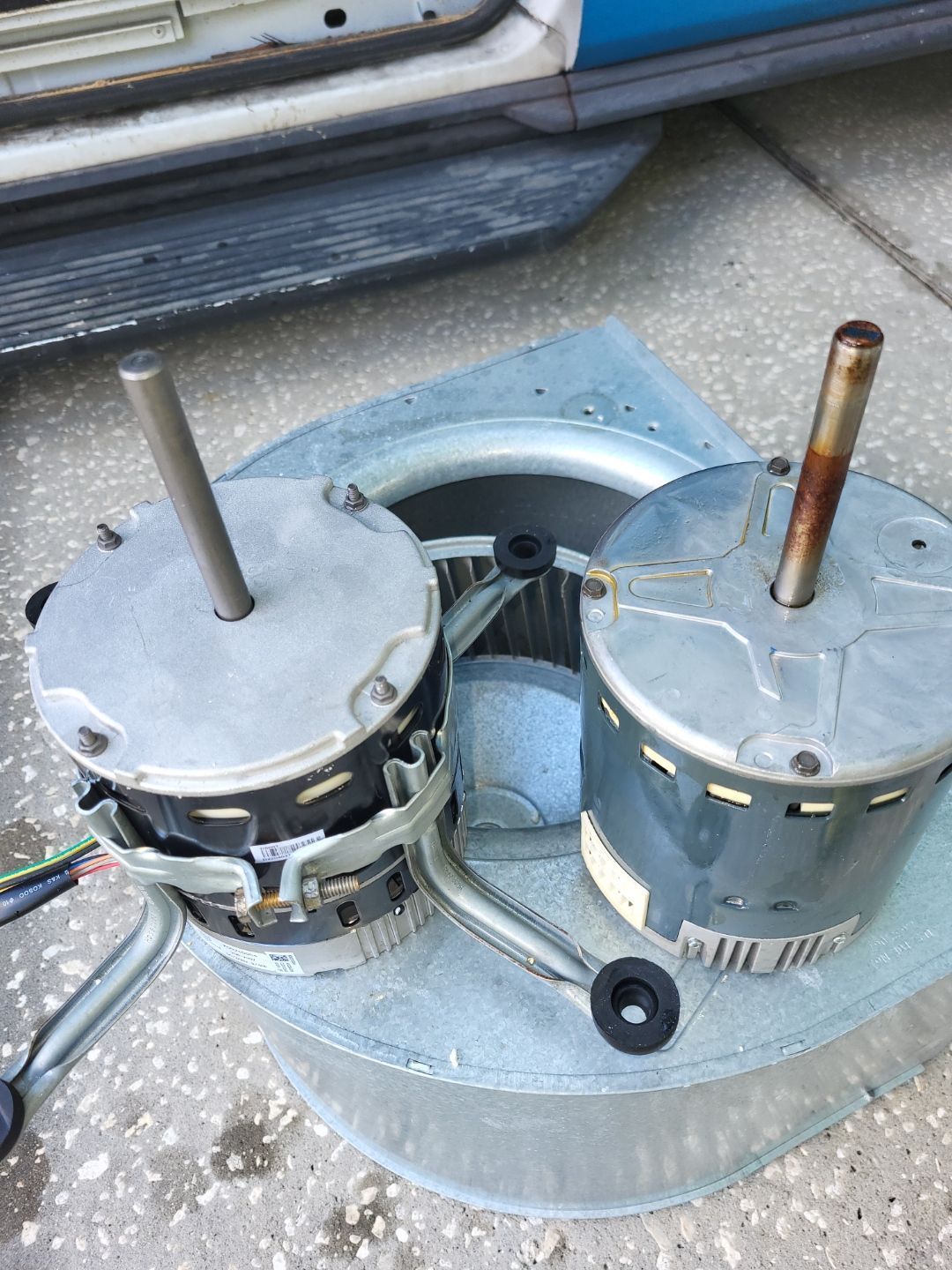 Two motors are sitting on top of each other on the ground.