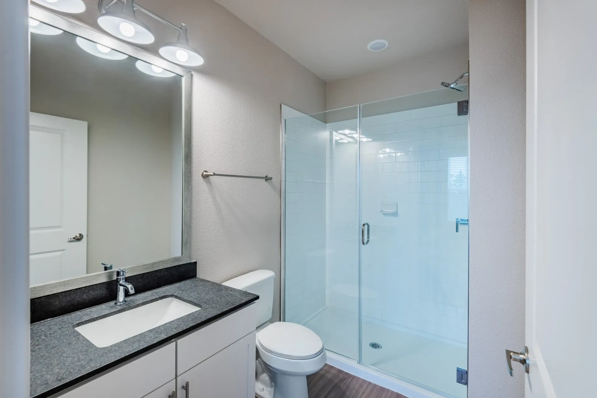 Modern bathroom with a vanity, toilet, and a glass-enclosed shower.