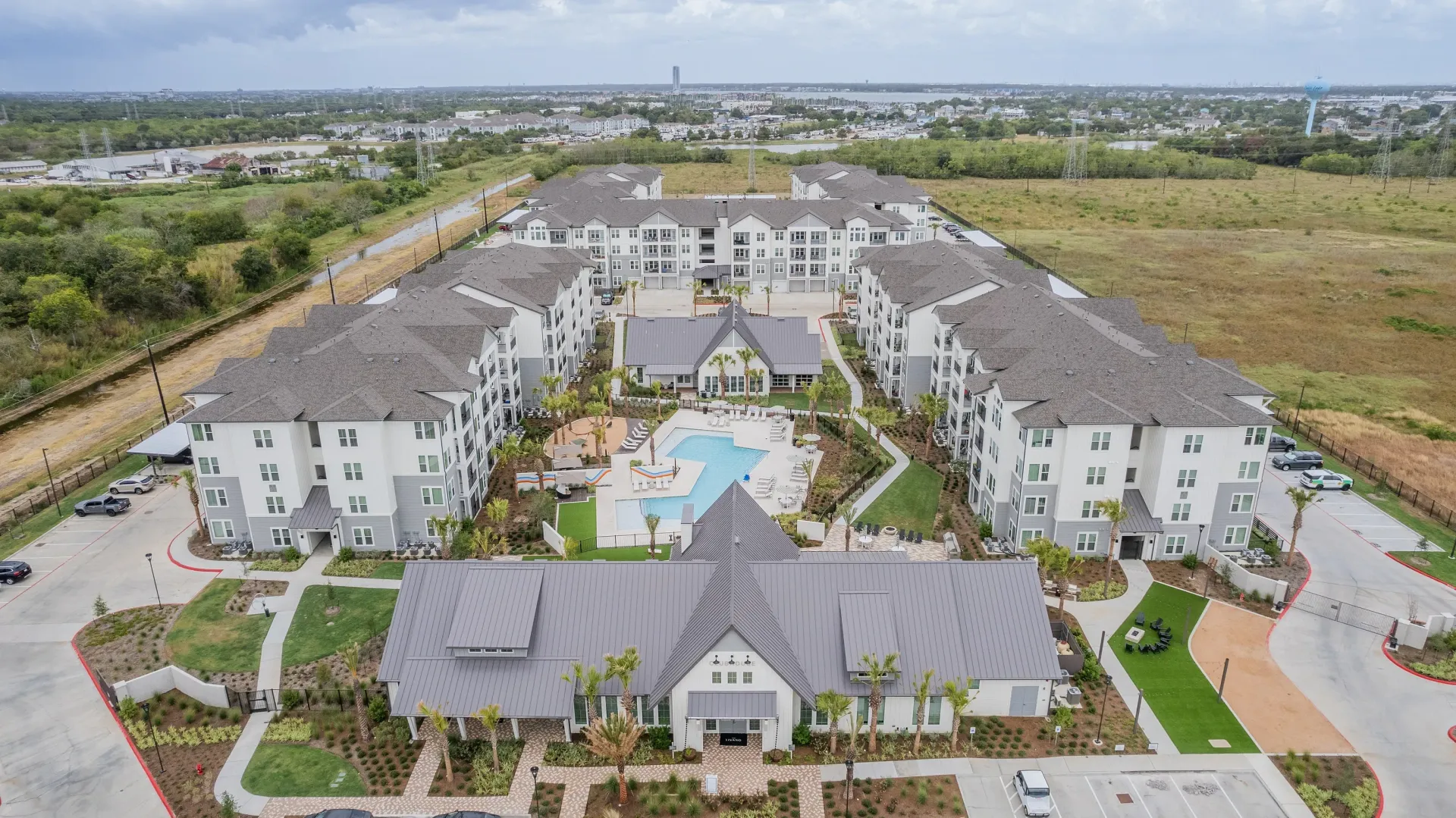 Aerial view of an apartment complex with a pool and clubhouse.