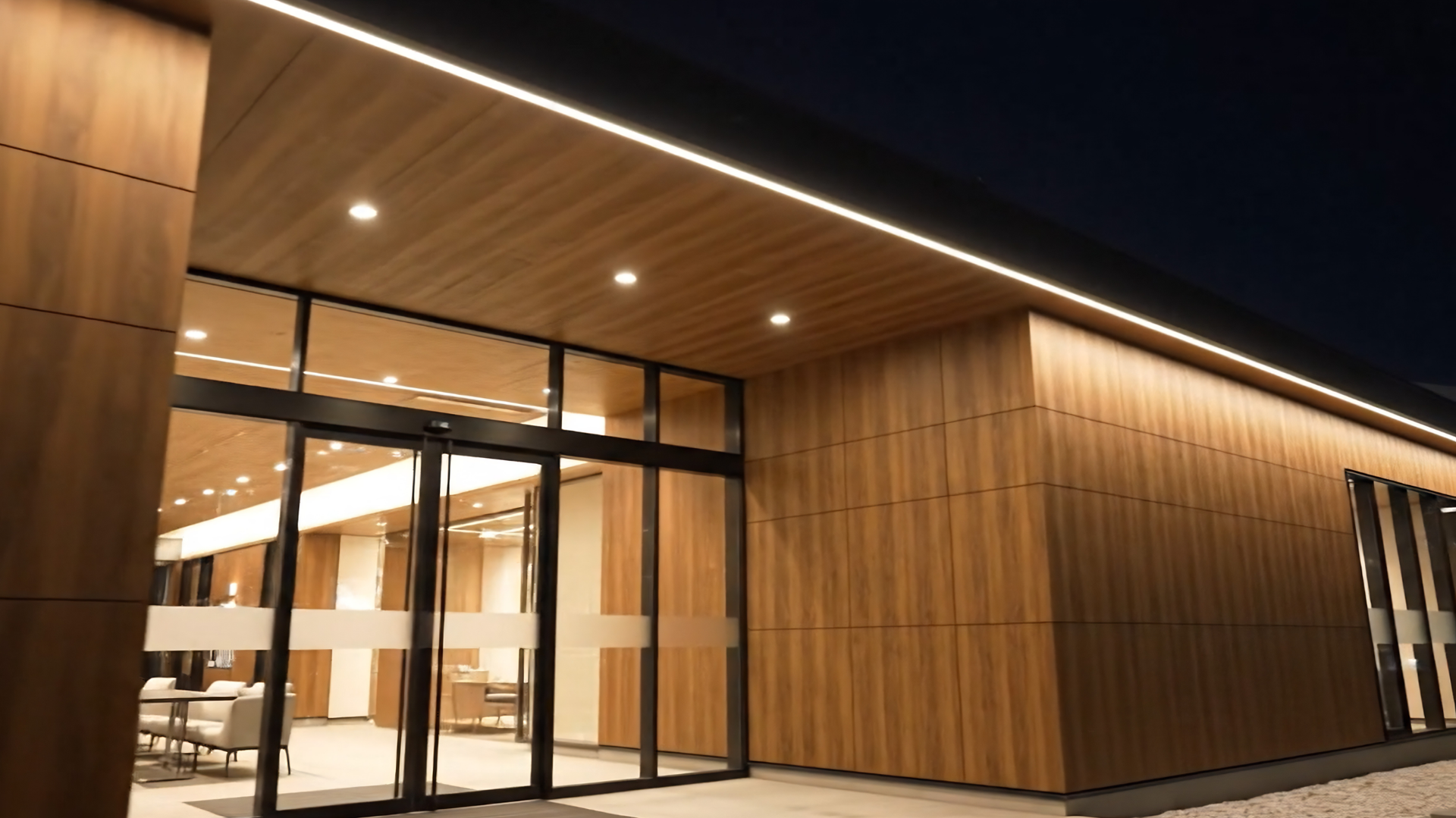 Dim exterior wall with warm lights illuminating a narrow walkway at night
