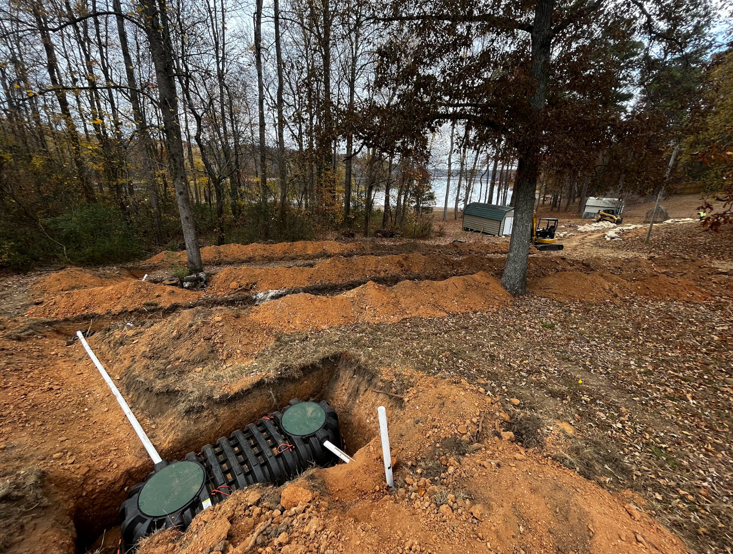 A septic tank is being installed in a dirt field.