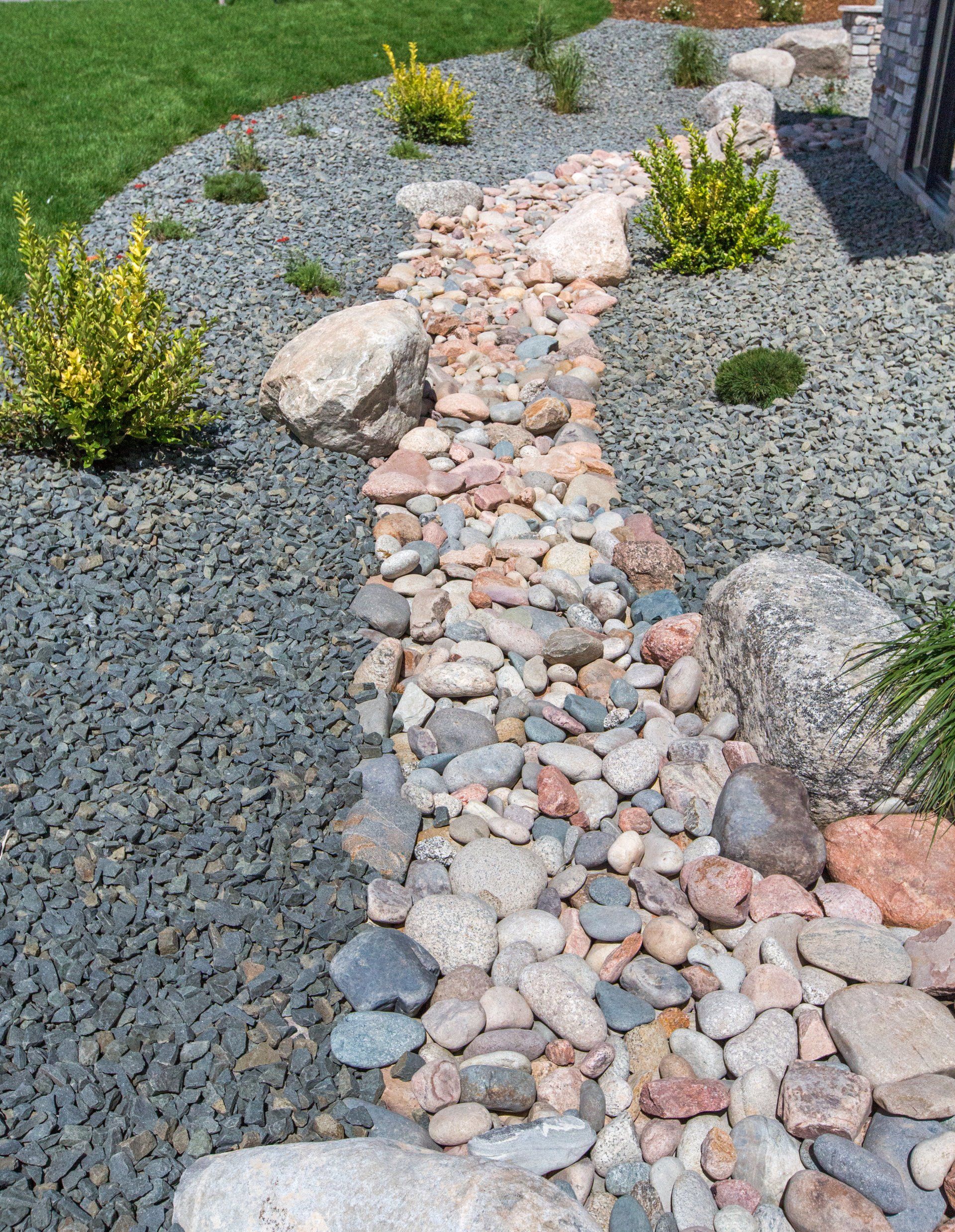 A stream of rocks and gravel in a garden.
