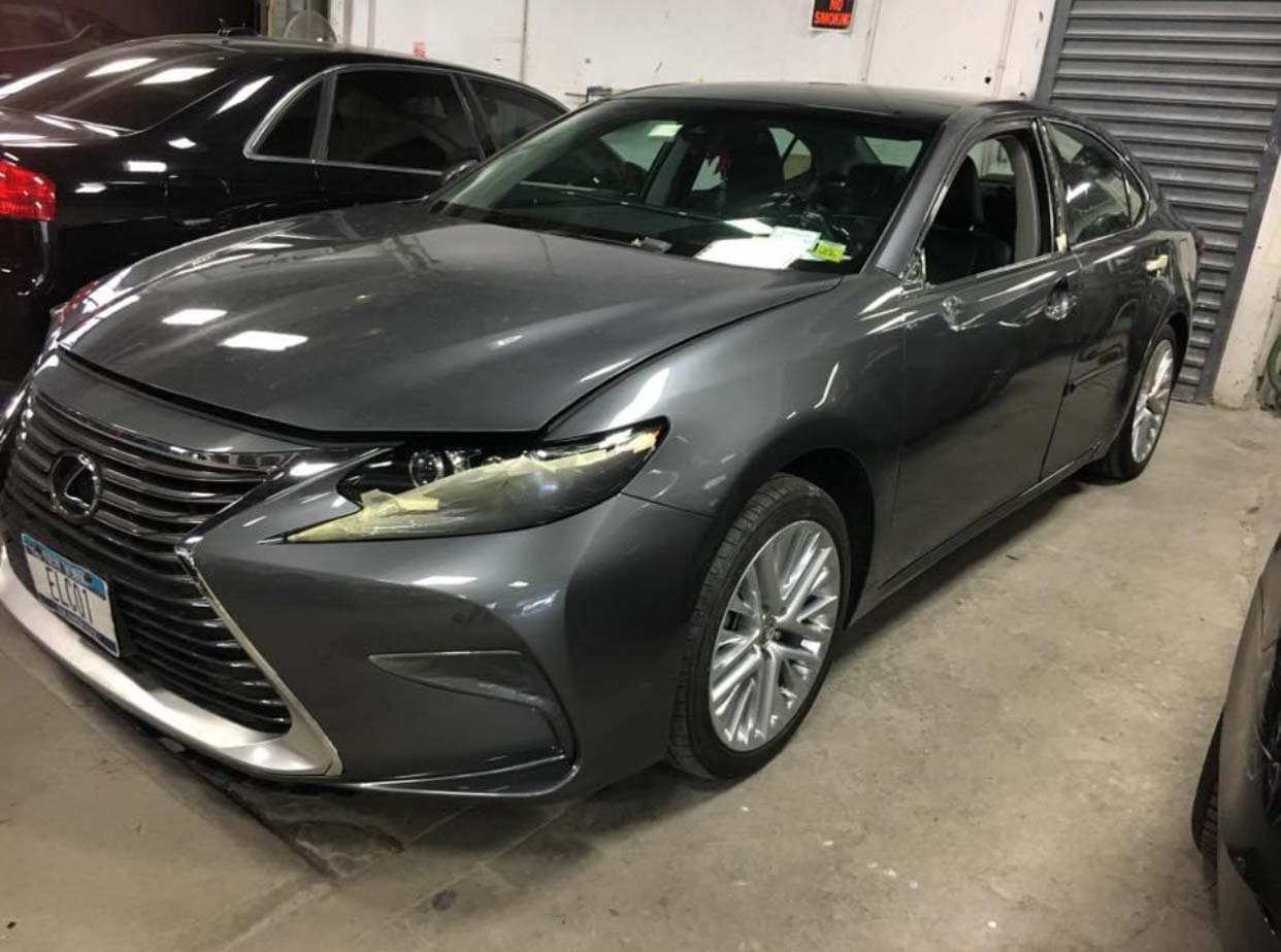 Gray sedan parked indoors at a dealership showroom, angled front view