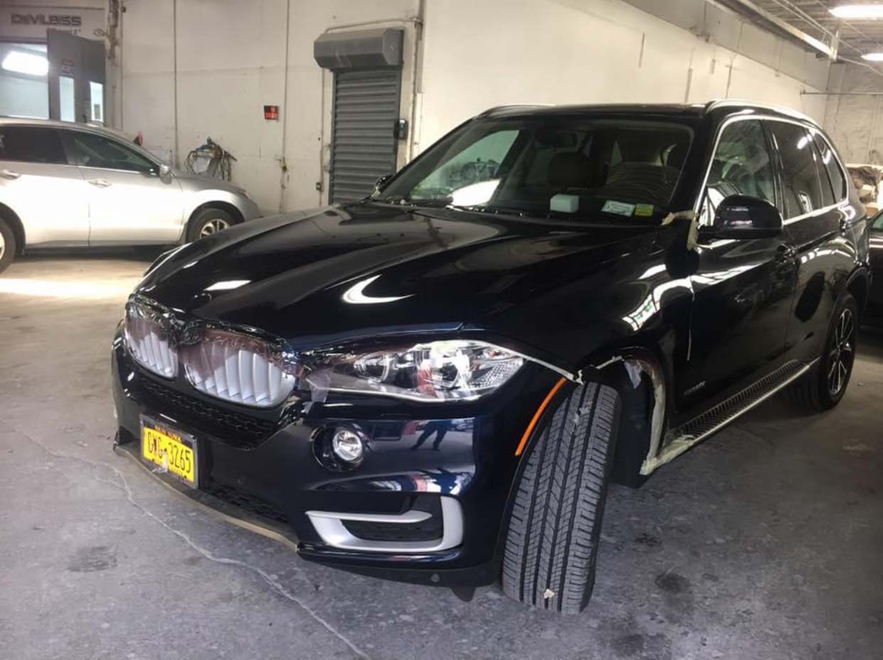 Black SUV parked indoors with a front wheel turned toward the camera