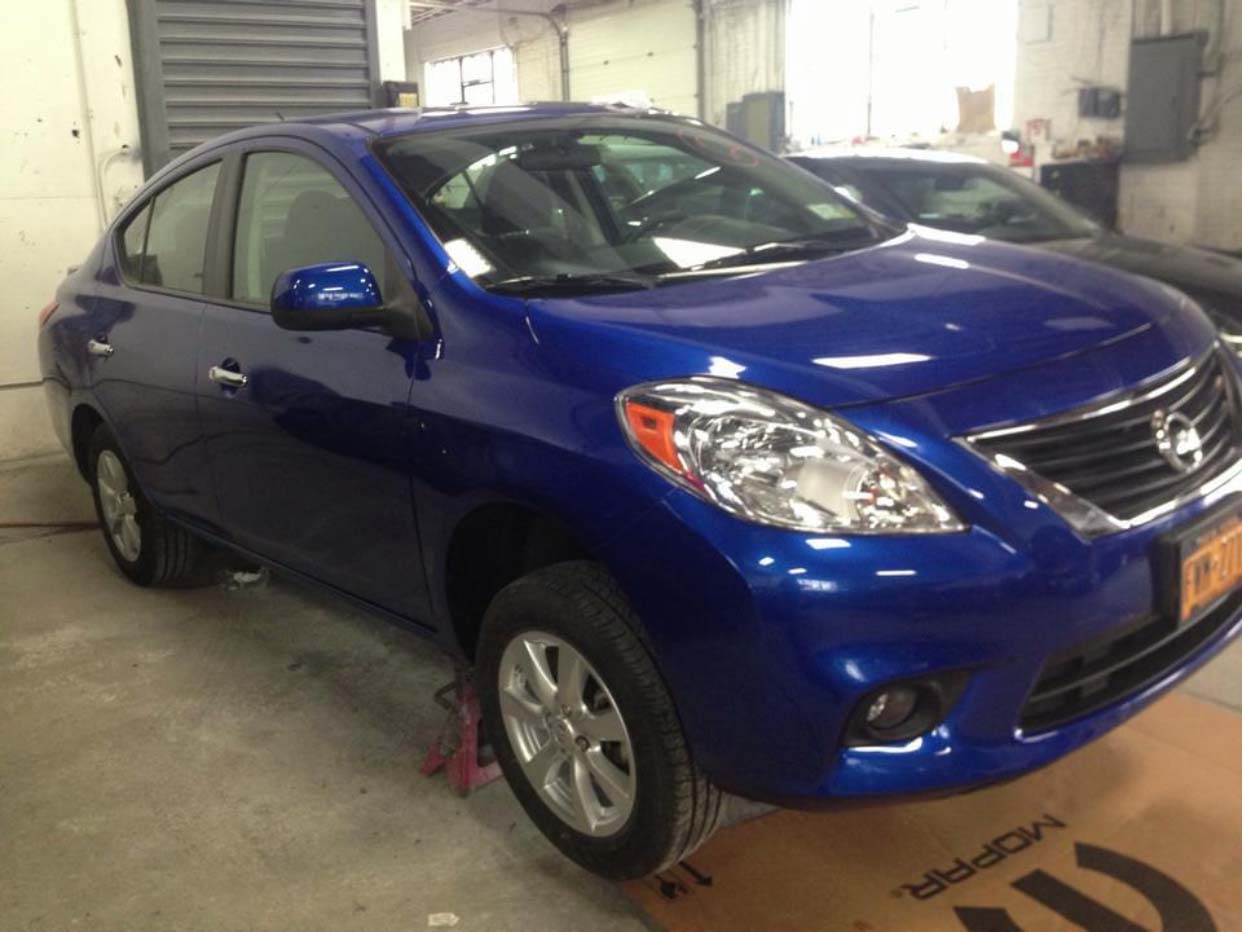 Blue sedan parked indoors in a garage, front-left view