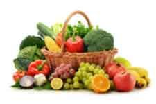Basket of assorted fresh fruits and vegetables with broccoli, apples, grapes, lemons, and tomatoes