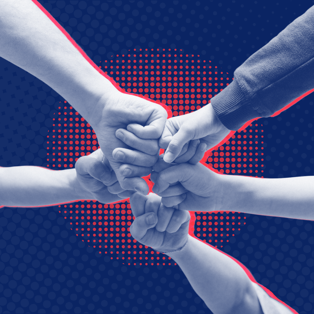 A group of people are putting their hands together in a circle.